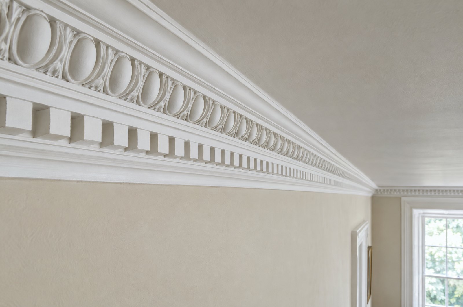 A long run of restored plaster crown molding with egg-and-dart and dentil detail